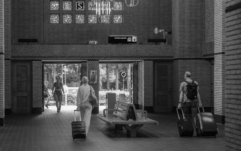 Travellers with luggage walking through an arrivals hall