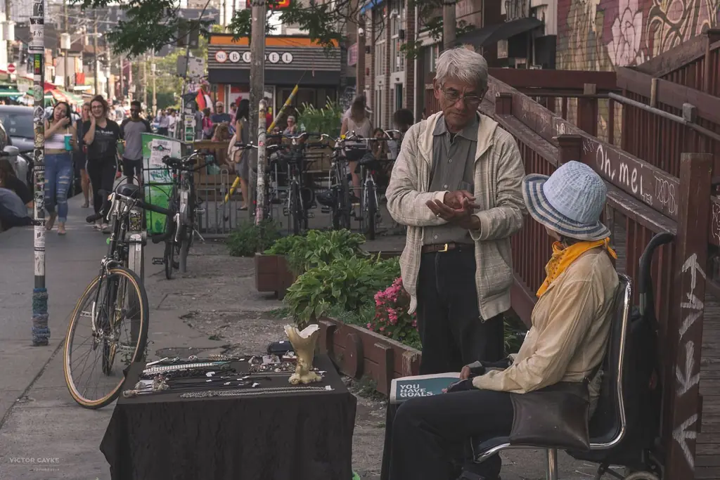 Candid moment captures street vendors talking in Toronto's Kensington Market