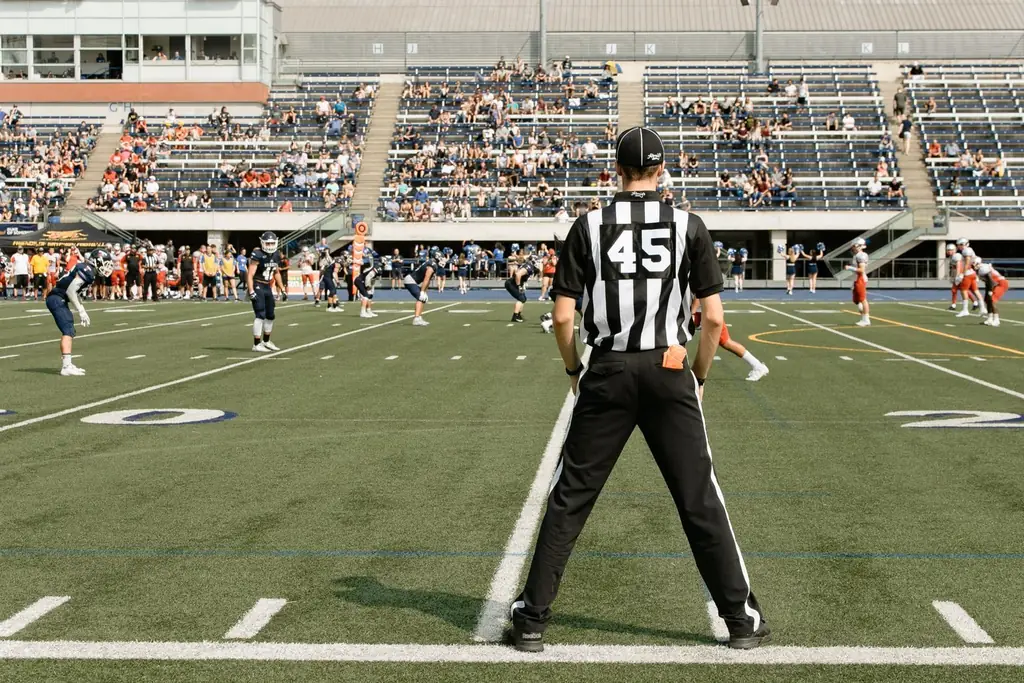 American football game with referee and players in action at a stadium in Toronto, Canada