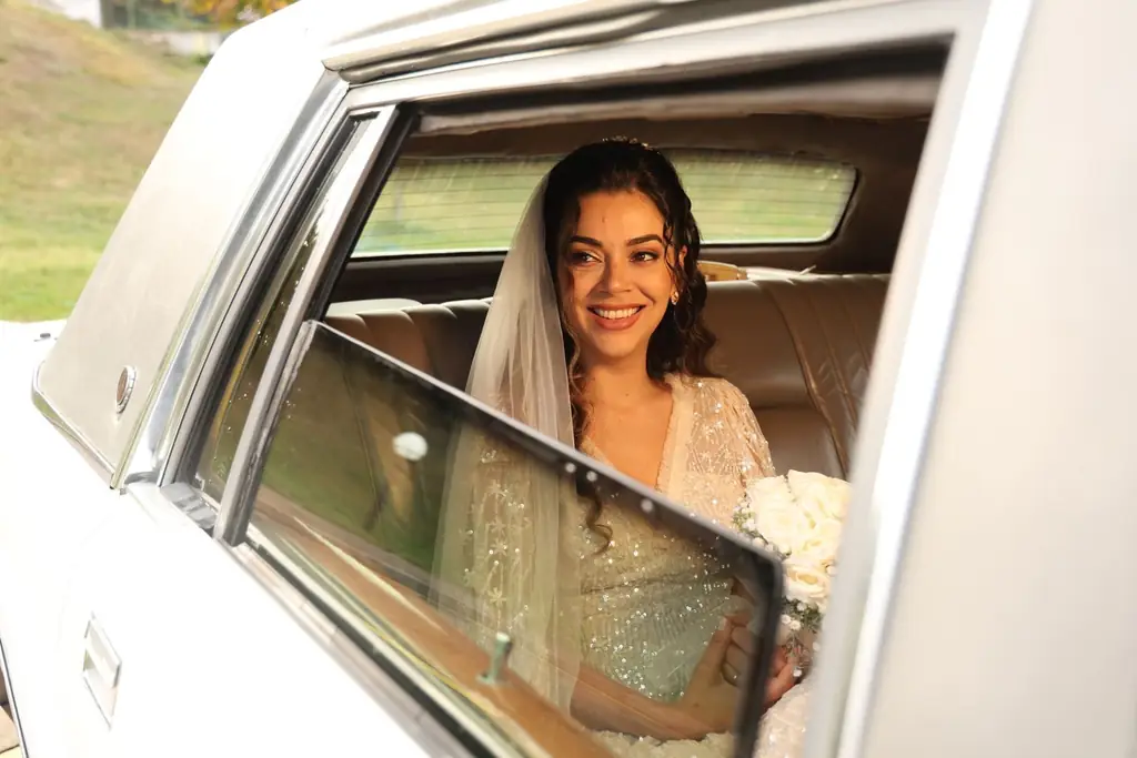 Radiant bride holding bouquet in a limousine, preparing for wedding ceremony