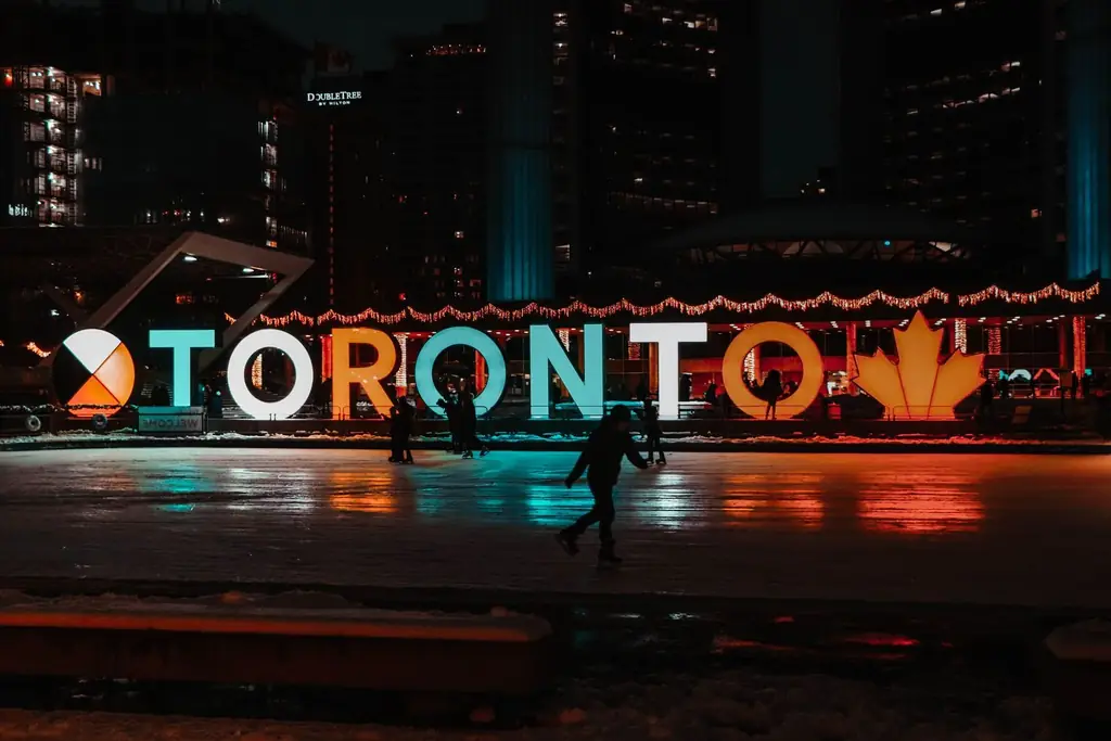 Ice skating scene at Toronto's iconic City Hall at night