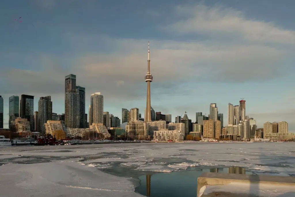 Winter view of Toronto skyline featuring the iconic CN Tower surrounded by ice