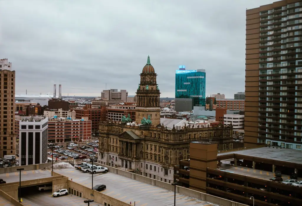 Aerial view of Detroit city showcasing historic and modern buildings under a cloudy sky