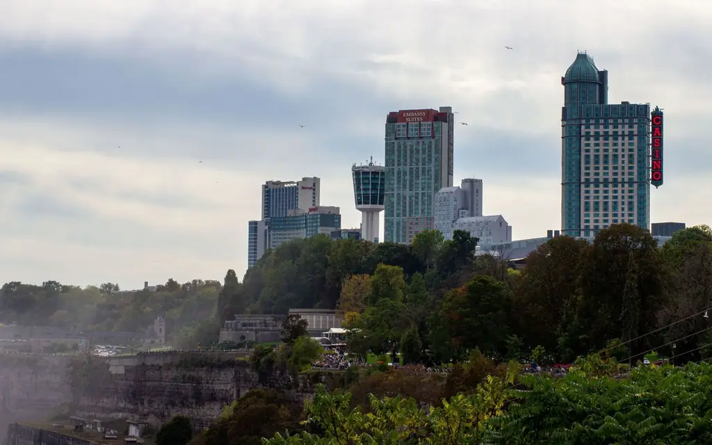 View of the Niagara Falls skyline featuring prominent hotels and casino amidst lush greenery