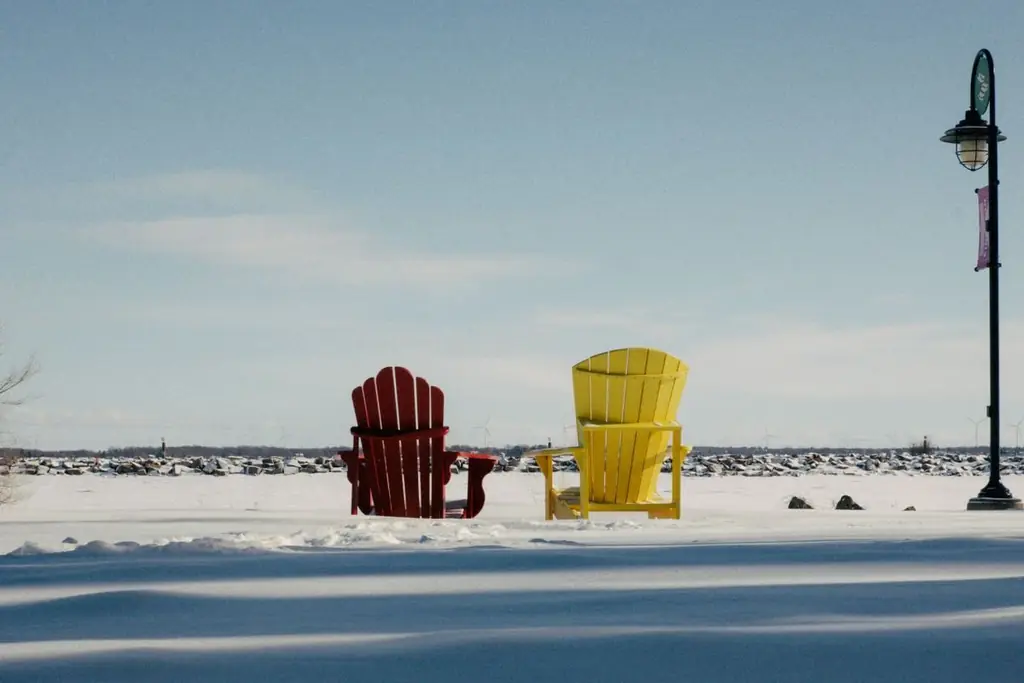 Bright chairs on a snowy waterfront in Kingston, Ontario under a clear blue sky