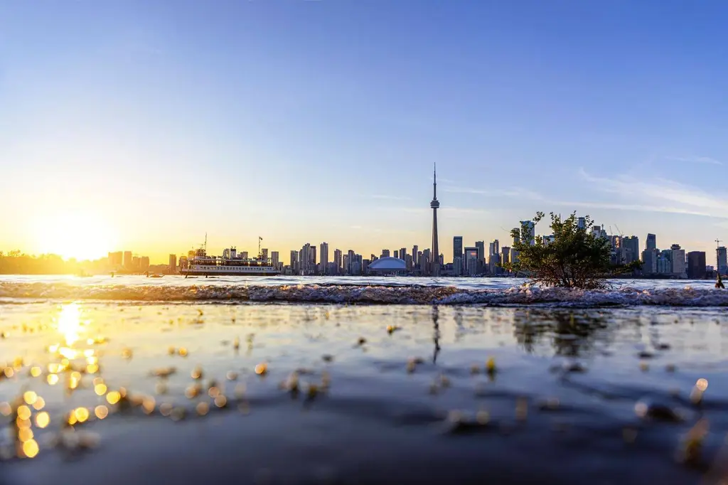 Sunset over Toronto skyline with the CN Tower and reflection on waterfront