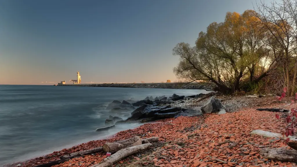 Lakeshore in Mississauga, Ontario with rocky beach and trees at sunset