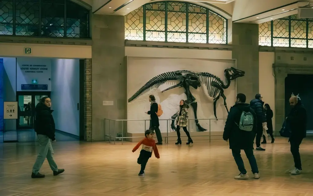 People exploring a dinosaur exhibit inside a Toronto museum