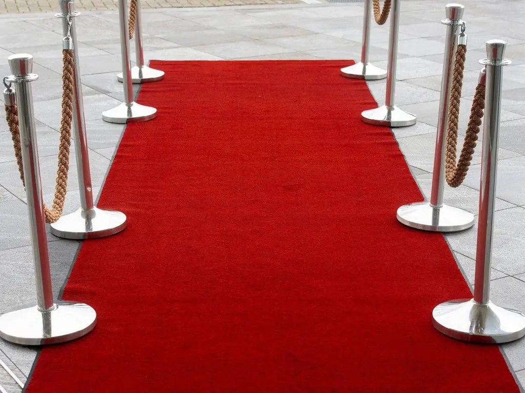 Red carpet entrance with stanchions on a tiled outdoor surface