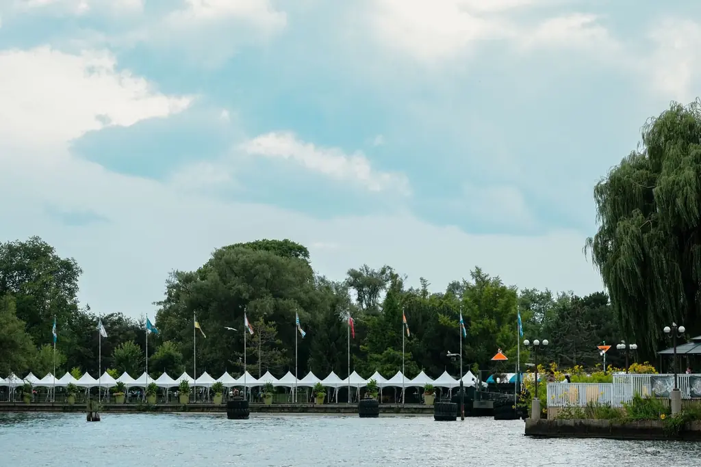 Waterfront view with trees and flags at Toronto's harbor in summer