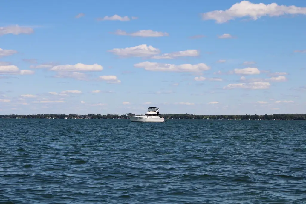 A motorboat cruising on Lake Simcoe with a clear sky and calm waters