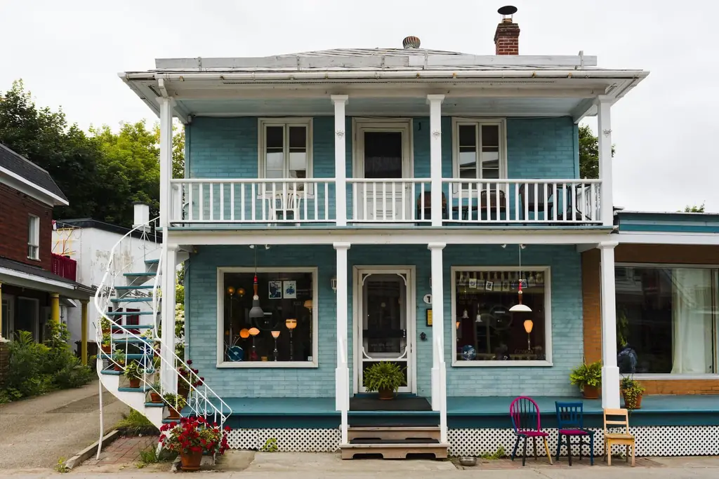 Front view of a charming blue house with balconies and twin lamps in Baie-Saint-Paul, Quebec