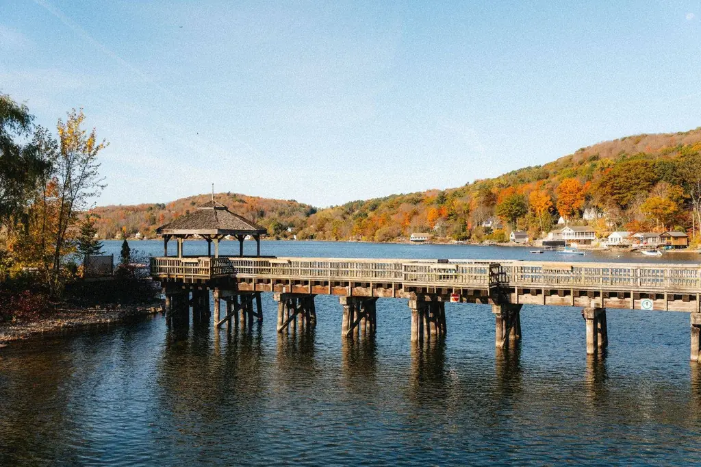 Pier against vibrant fall foliage on a calm lake in North Hatley, Canada