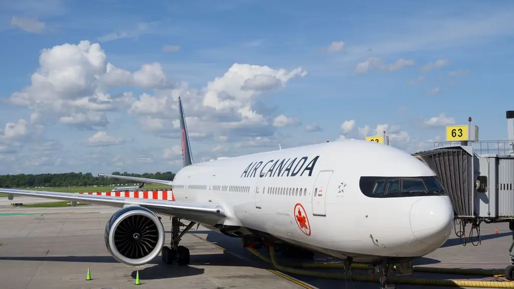 Air Canada Boeing 777 airplane parked at an airport gate under a clear blue sky