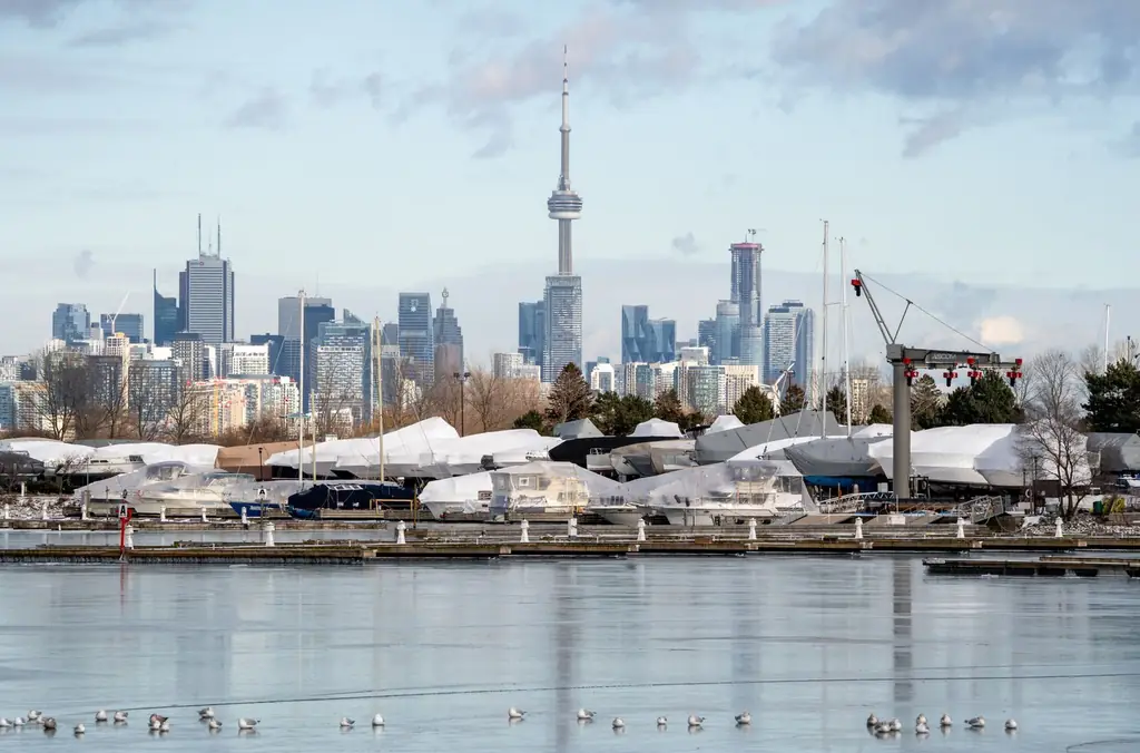 Toronto skyline featuring the CN Tower with docked boats and a winter setting
