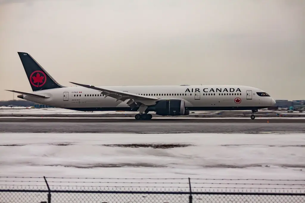 Air Canada jet taxiing past snowy fields at the airport