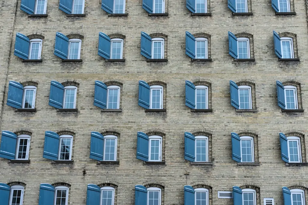 A symmetrical brick building in Waterloo, ON with blue shutters creating a geometric pattern