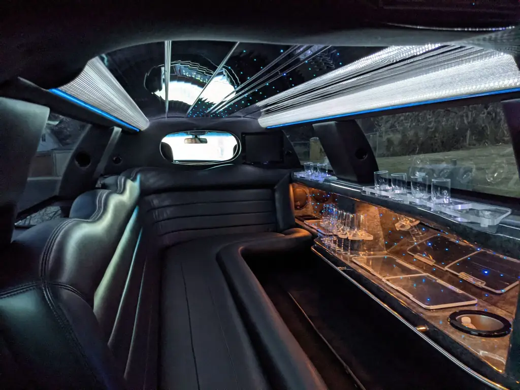 Plush interior of a luxury limousine featuring ambient lighting and comfortable seating