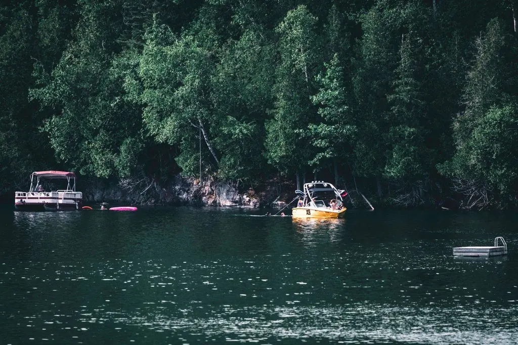 Idyllic lake setting in Mont-Tremblant with boats near lush green forest