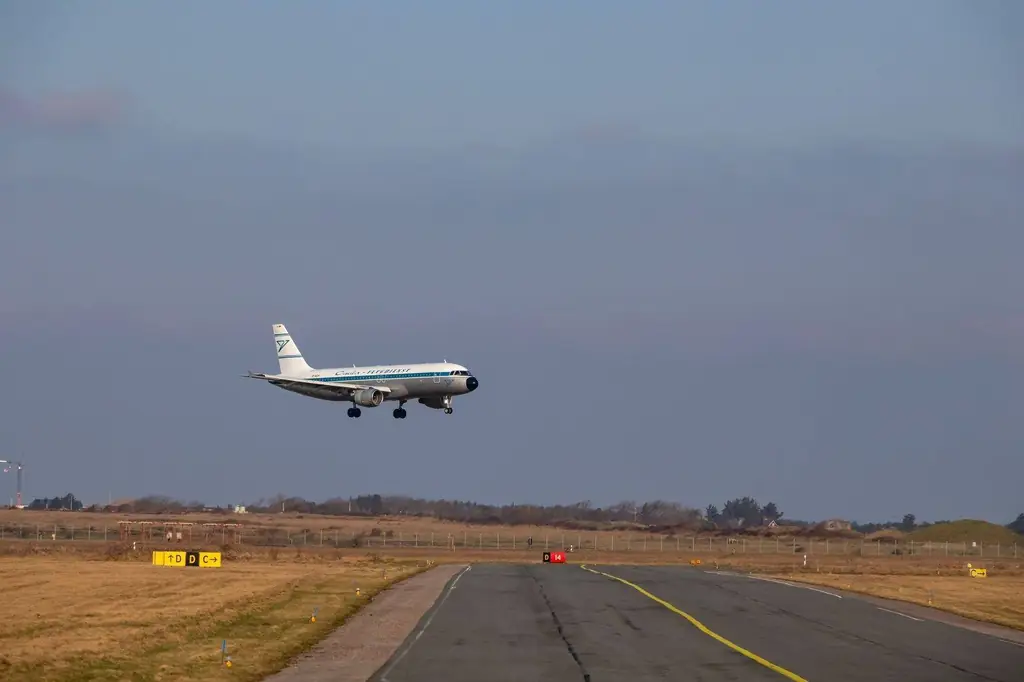 Airplane approaching runway for landing at airport with clear sky background