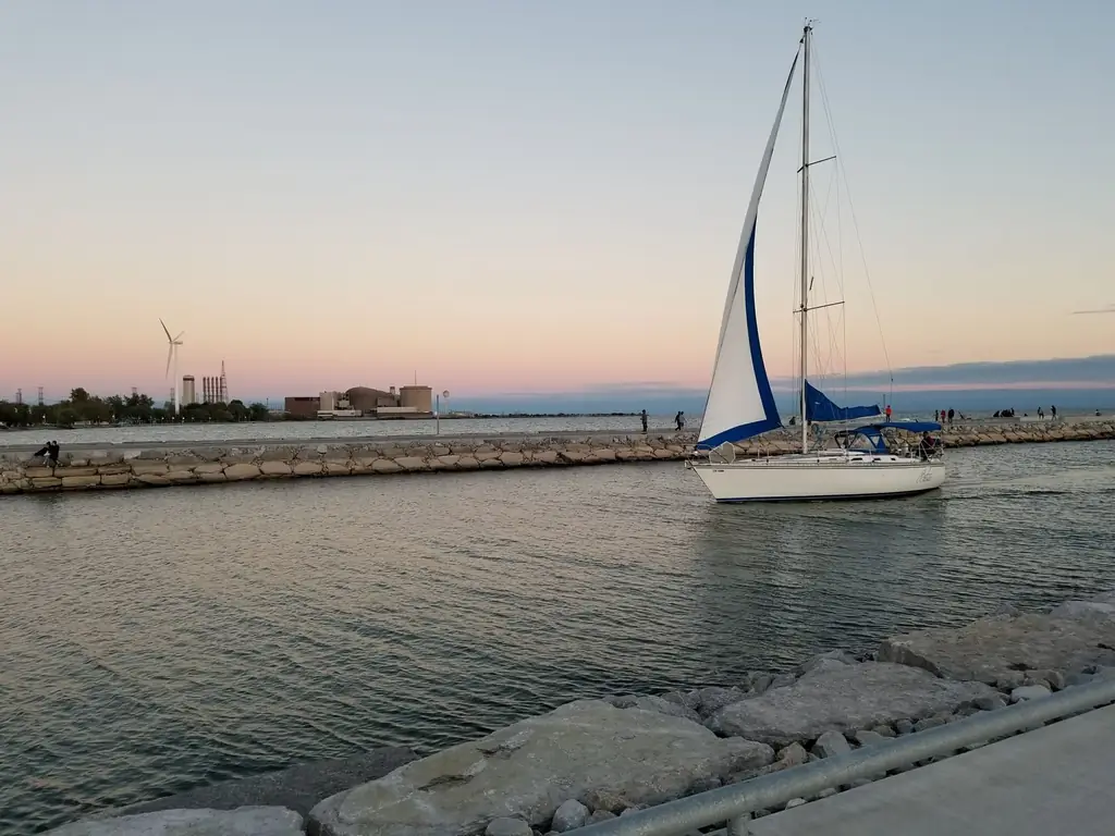 Sailboat cruising on tranquil waters at sunset in Pickering, Ontario, Canada