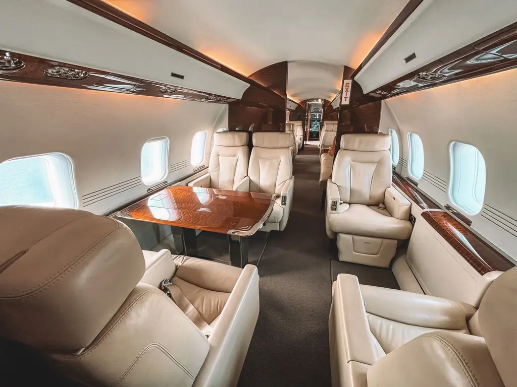 Luxurious interior of a private jet showcasing leather seating and elegant wooden trim