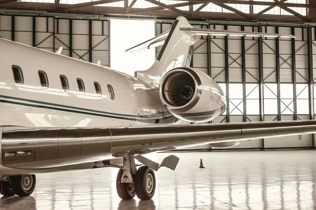 Private jet parked inside a modern hangar