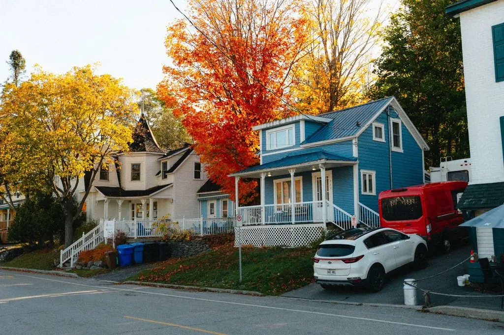 Colorful houses surrounded by vibrant autumn foliage in North Hatley, Québec, Canada