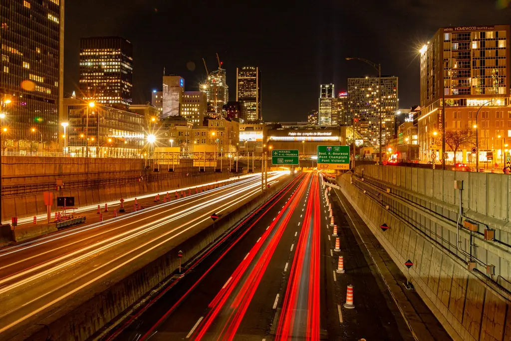 Long exposure of Montreal highway at night showing vibrant city lights and traffic trails