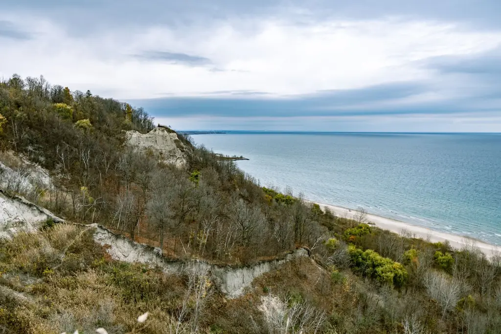 View of Scarborough Bluffs meeting Lake Ontario under a cloudy sky