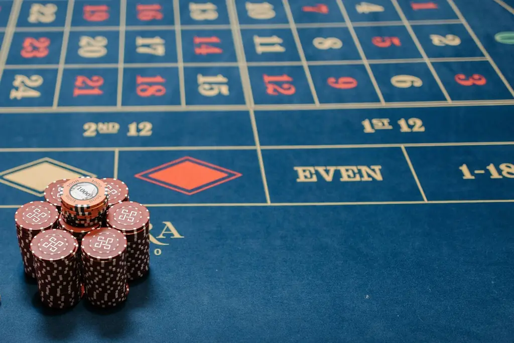 Detailed image of a roulette table with poker chips stacked