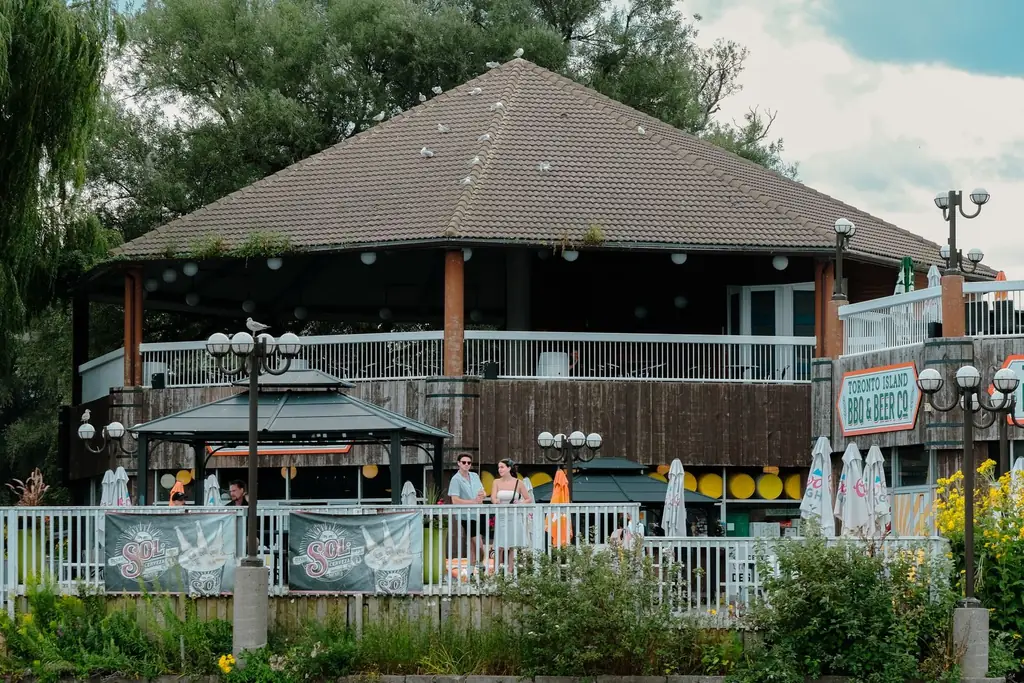 A rustic restaurant on Toronto Island, Canada with lush greenery and outdoor seating