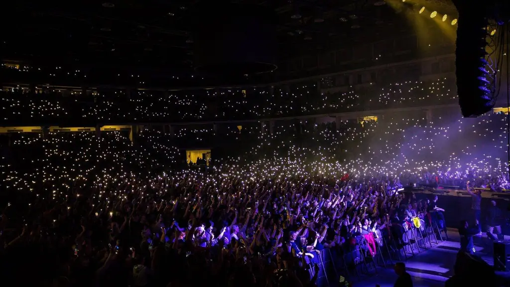 A packed indoor concert with audience lights creating a stunning visual display