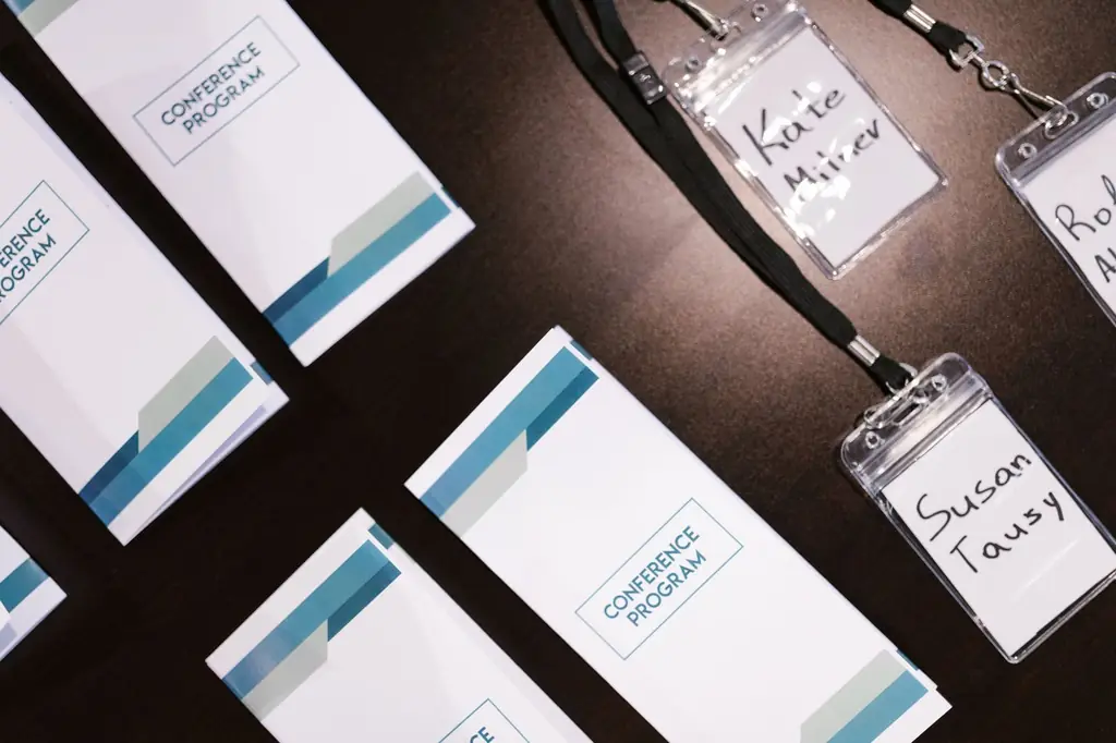High-angle view of conference programs and name badges on a table