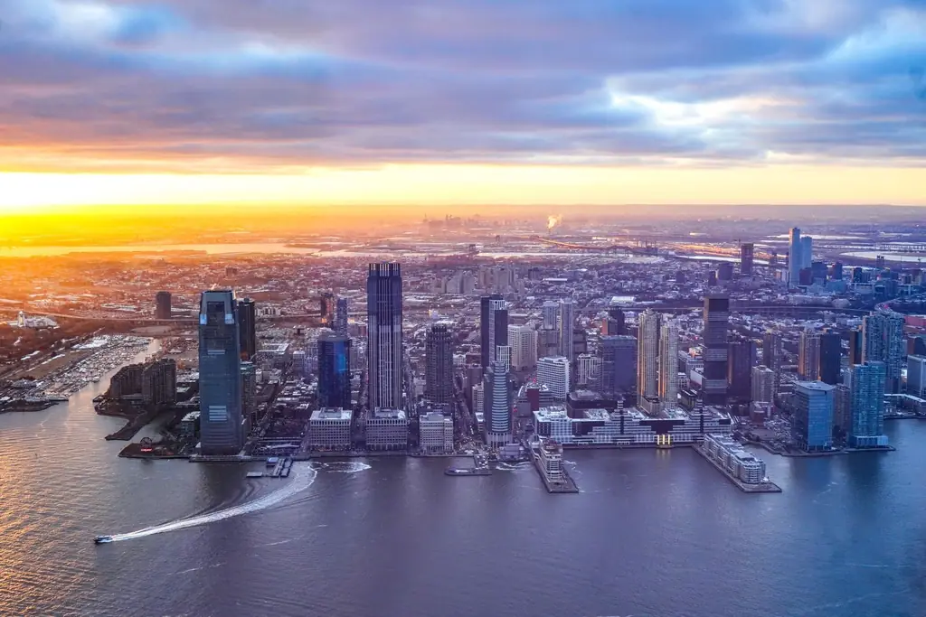 Aerial view of Jersey City's modern skyline at sunset with vibrant colors and skyscrapers