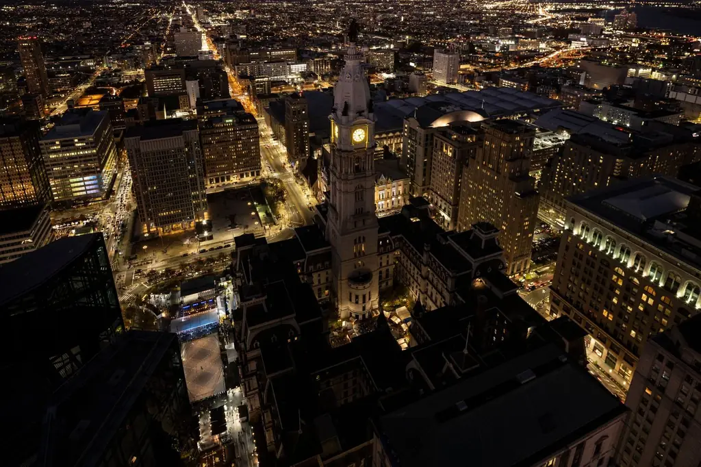 Aerial view of Philadelphia cityscape featuring City Hall illuminated at night
