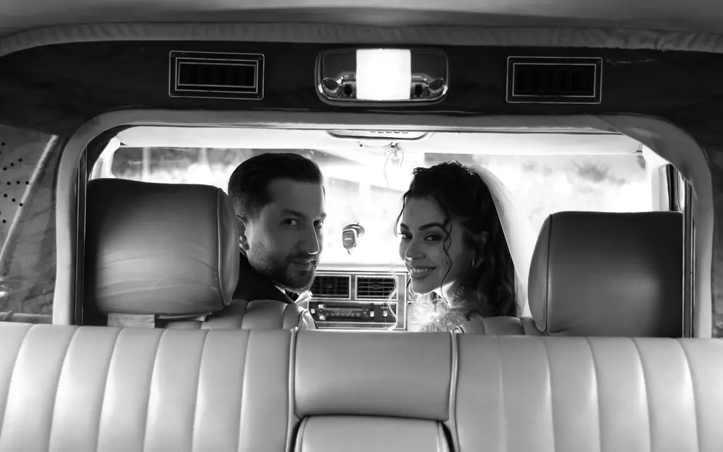 Bride and groom in the back seat of a car